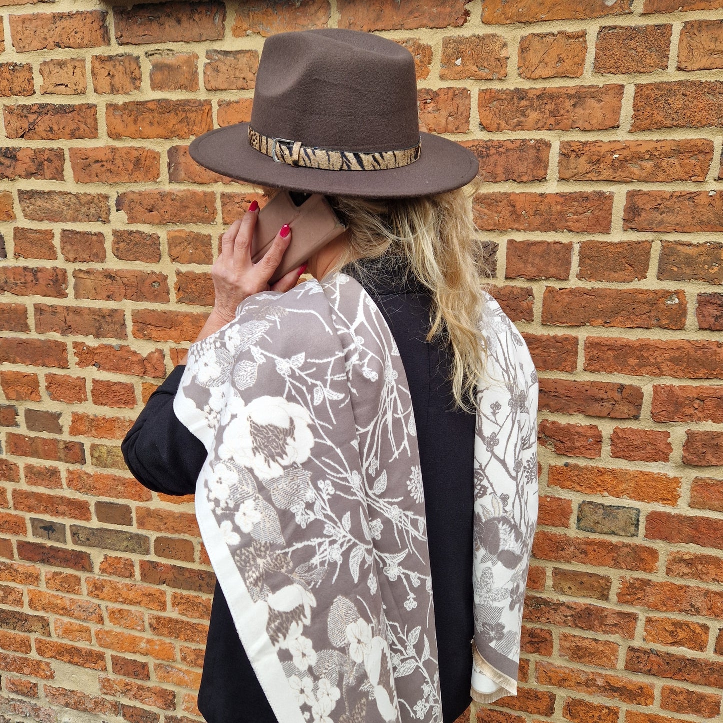 Lady wearing reversible cream and mocha coloured scarf in a Hedgerow print.