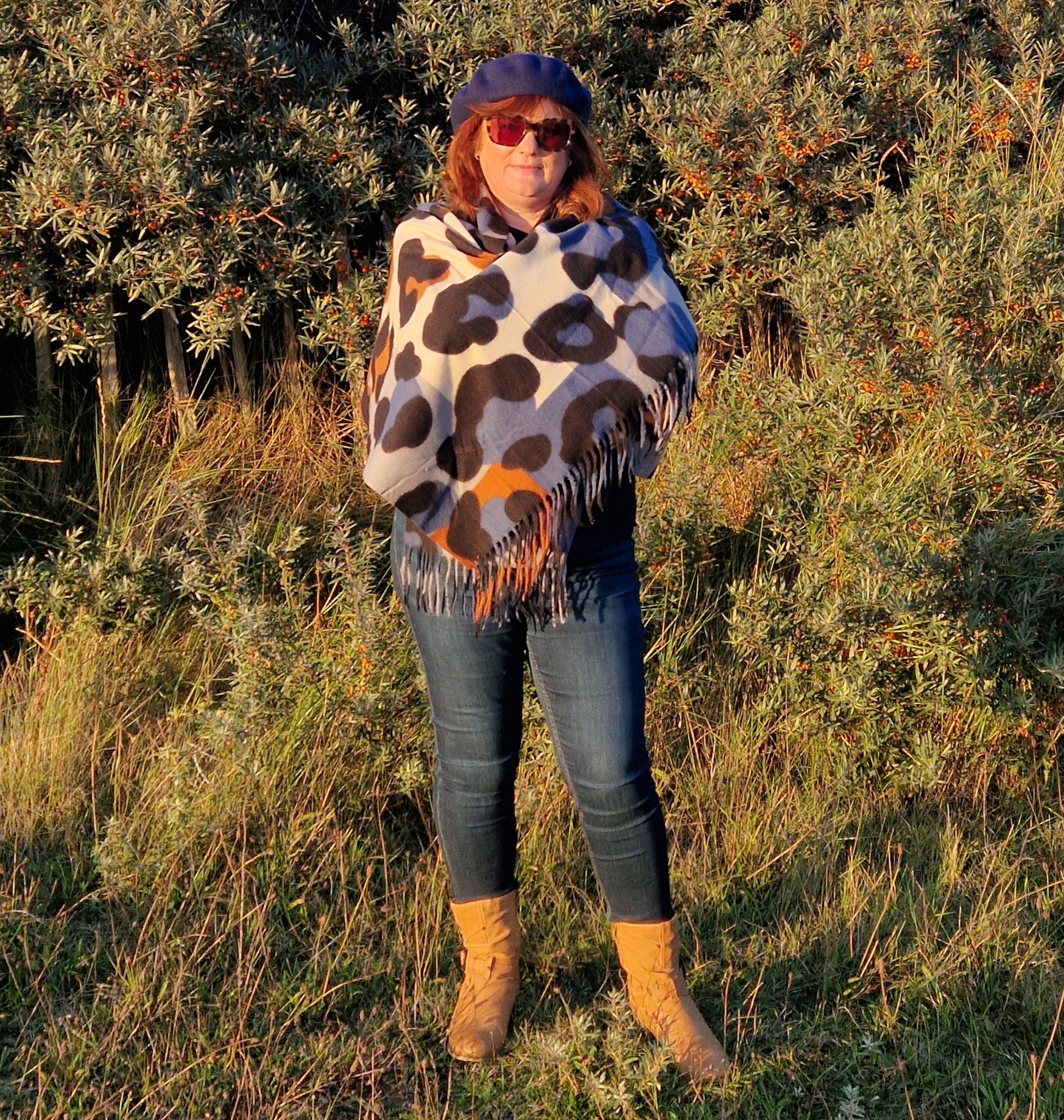 Lady wearing an abstract leopard print scarf in blue, grey, black, cream and tan colourings.