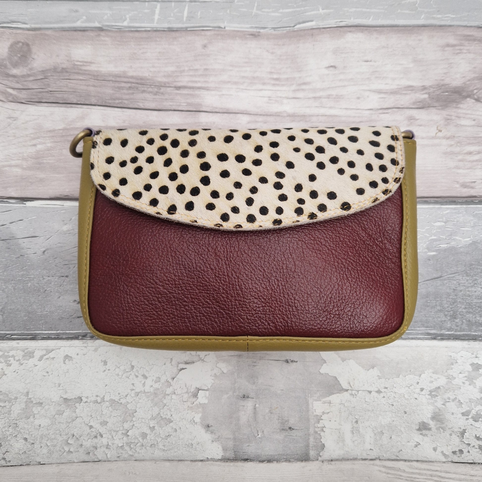 Leather crossbody bag in brown and mustard colours with a textured panel of black and white spot print.