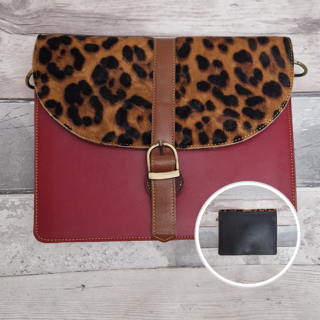 All leather near square shaped crossbody bag with a buckle. Red coloured with a textured panel in a Jaguar print. Black back.