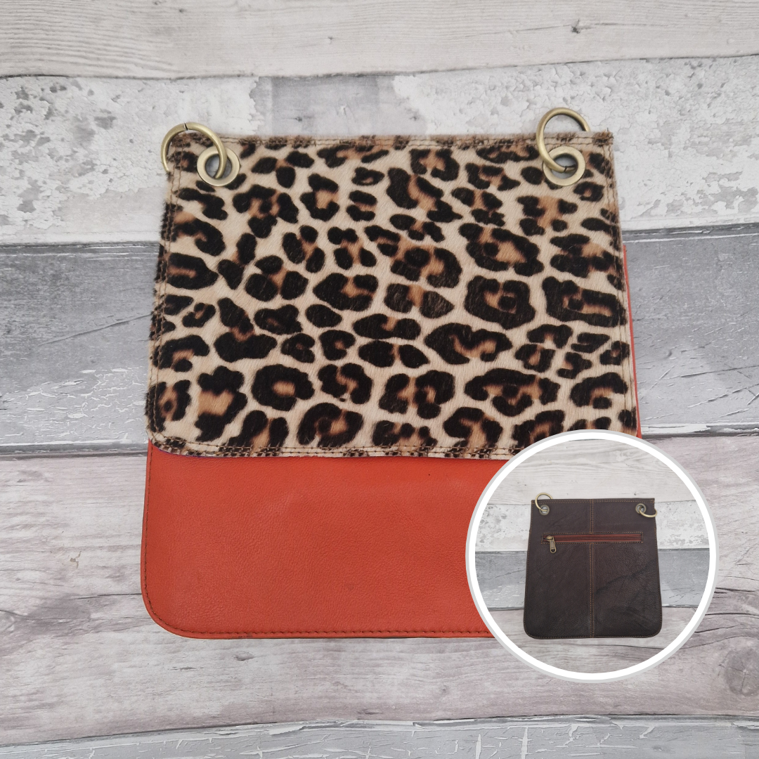 All leather modern messenger style bag with a bright orange panel and textured leopard print panel.