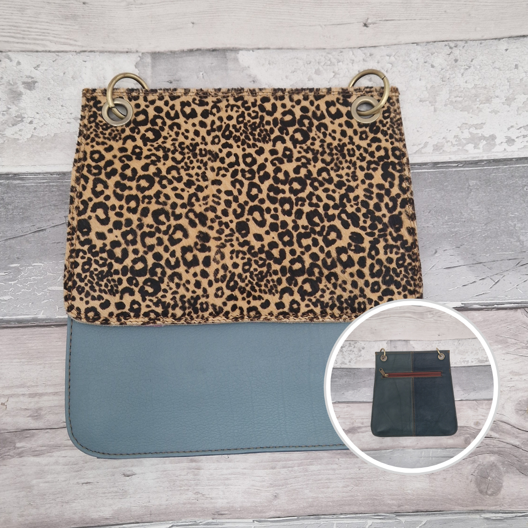 All leather modern messenger style bag with a stone blue panel and textured cheetah print panel.