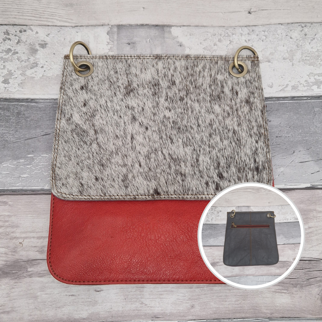 All leather modern messenger style bag with a bright red panel and textured white and grey pony print panel.