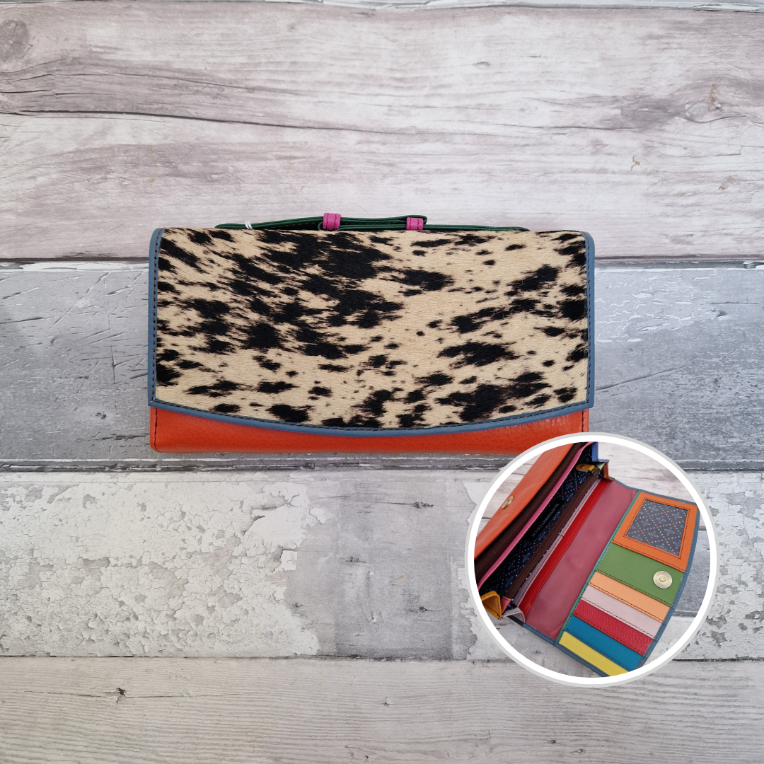 All leather purse with a tomato and blue coloured exterior and textured panel of cow print.