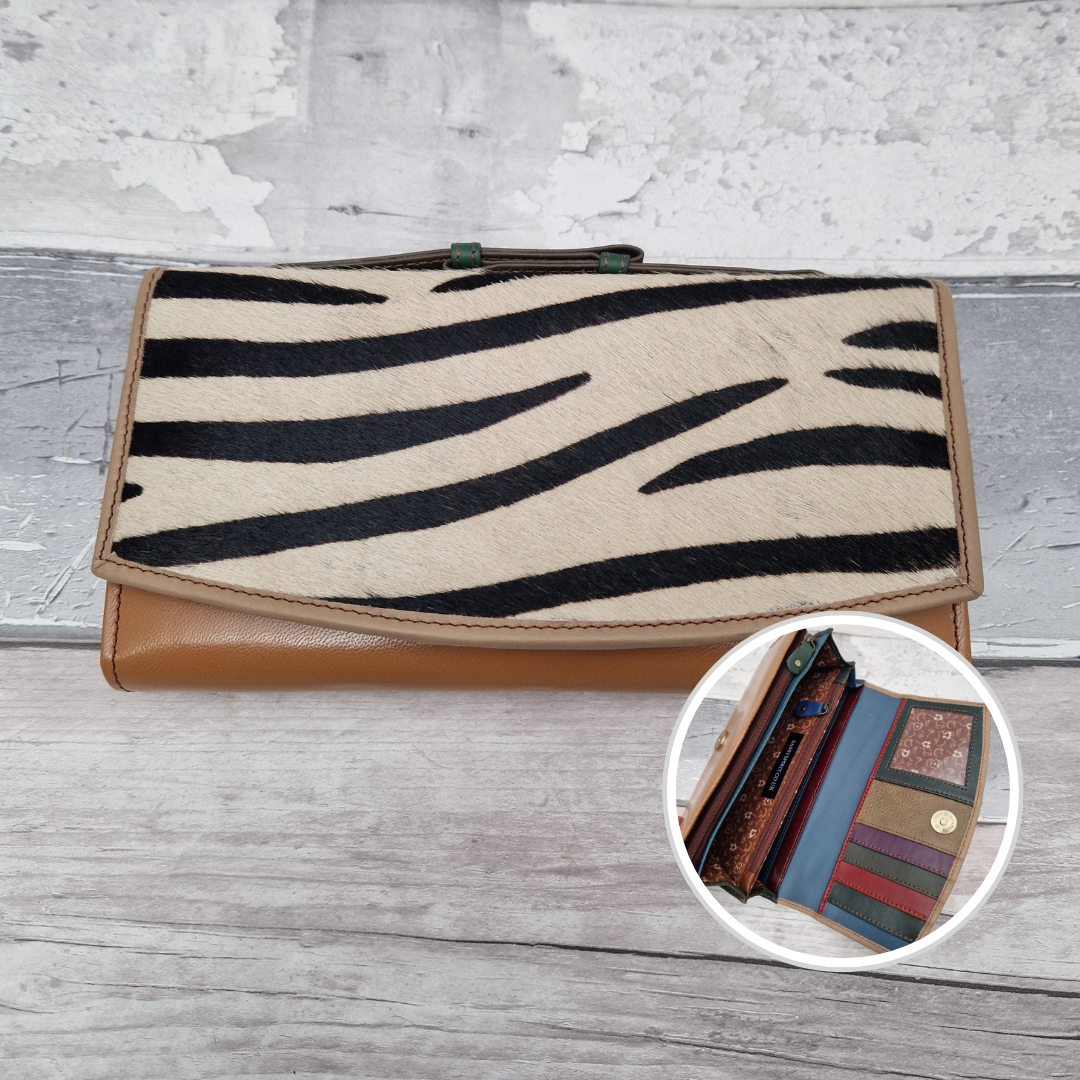 All leather purse with a beige coloured exterior and textured panel of zebra print.