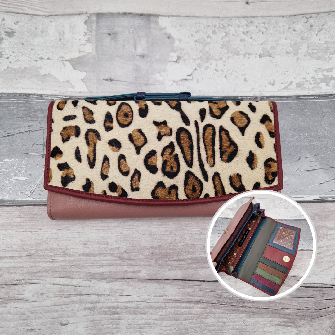 All leather purse with a pink and dark red coloured exterior and textured panel of abstract leopard print.