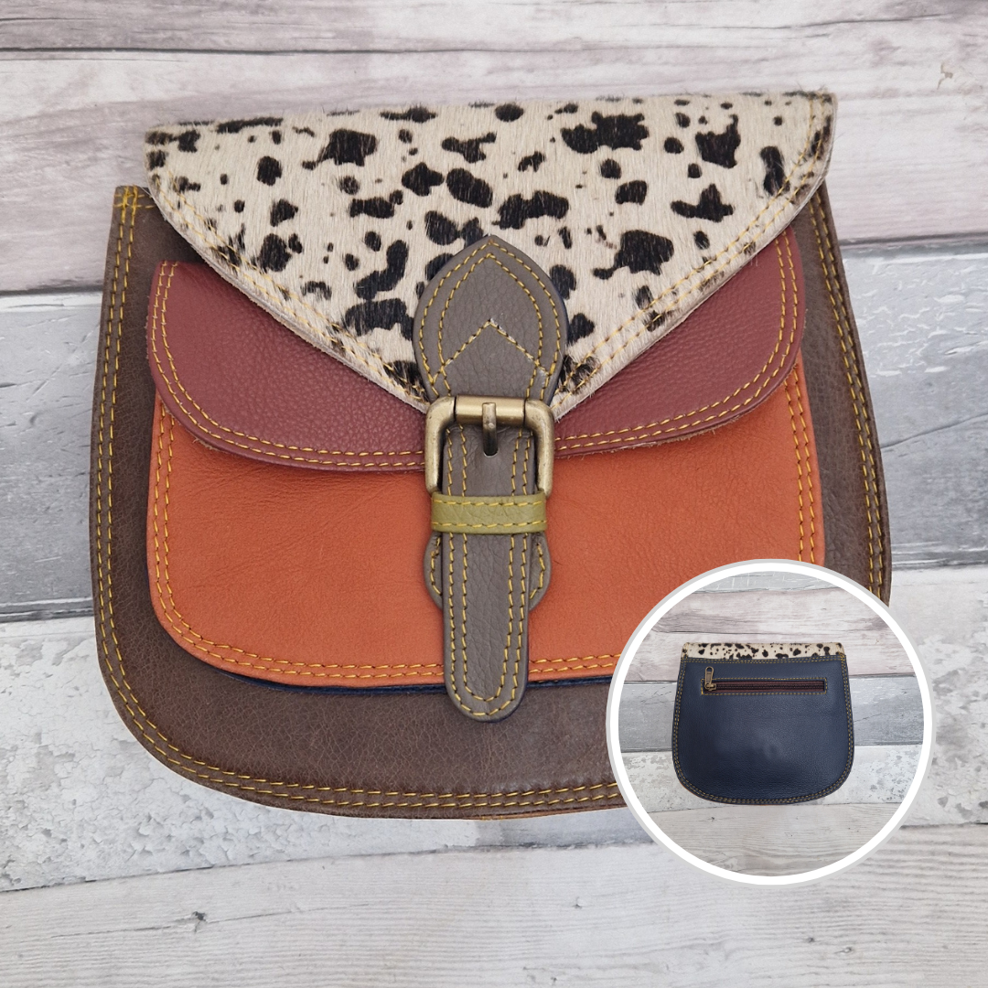 Saddlebag style bag in brown leather with contrasting coloured panels and a section of textured cow print