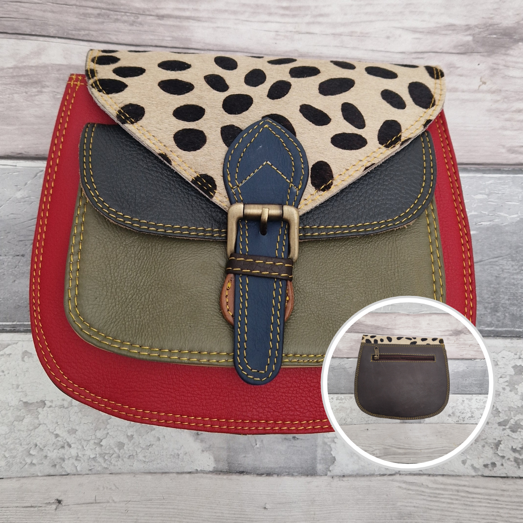 Saddlebag style bag in red leather with contrasting coloured panels and a section of textured spot print