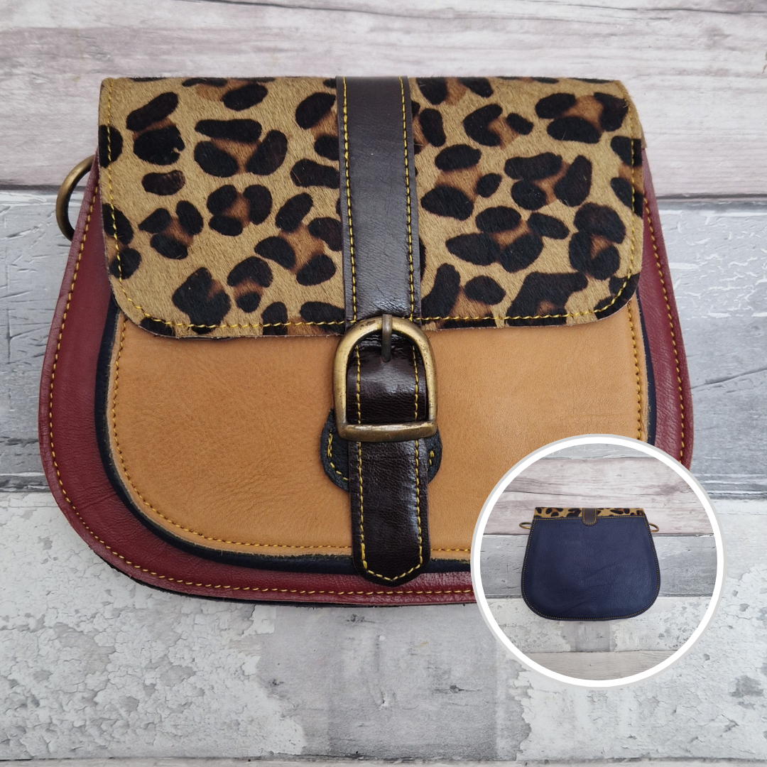 All leather saddlebag style ladies bag in dark red and golden with a textured panel of Jaguar print.. Brass buckle closer.