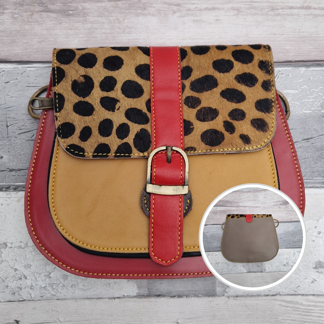 All leather saddlebag style ladies bag in red and golden with a textured panel of spotty print. Brass buckle closer.