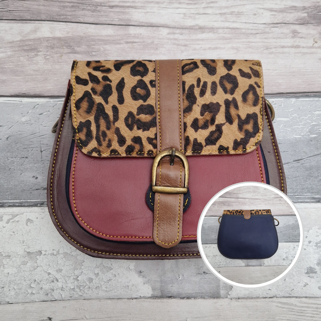 All leather saddlebag style ladies bag in mahogany and red with a textured panel of leopard print. Brass buckle closer.