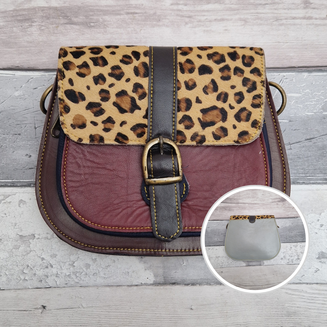 All leather saddlebag style ladies bag in dark red and mahogany with a textured panel of leopard print. Brass buckle closer.