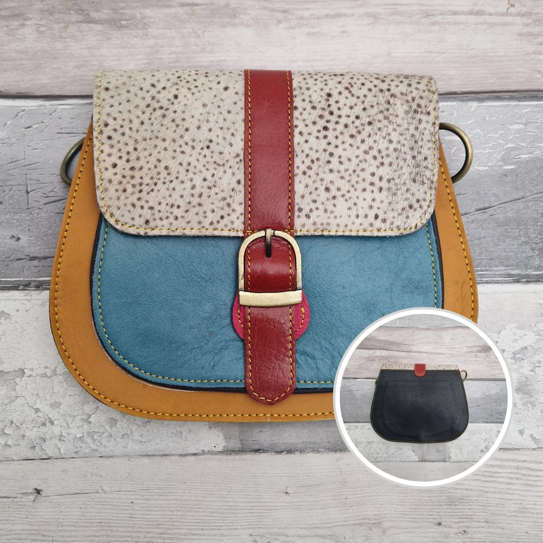 All leather saddlebag style ladies bag in golden and turquoise with a textured panel of spot print. Brass buckle closer.