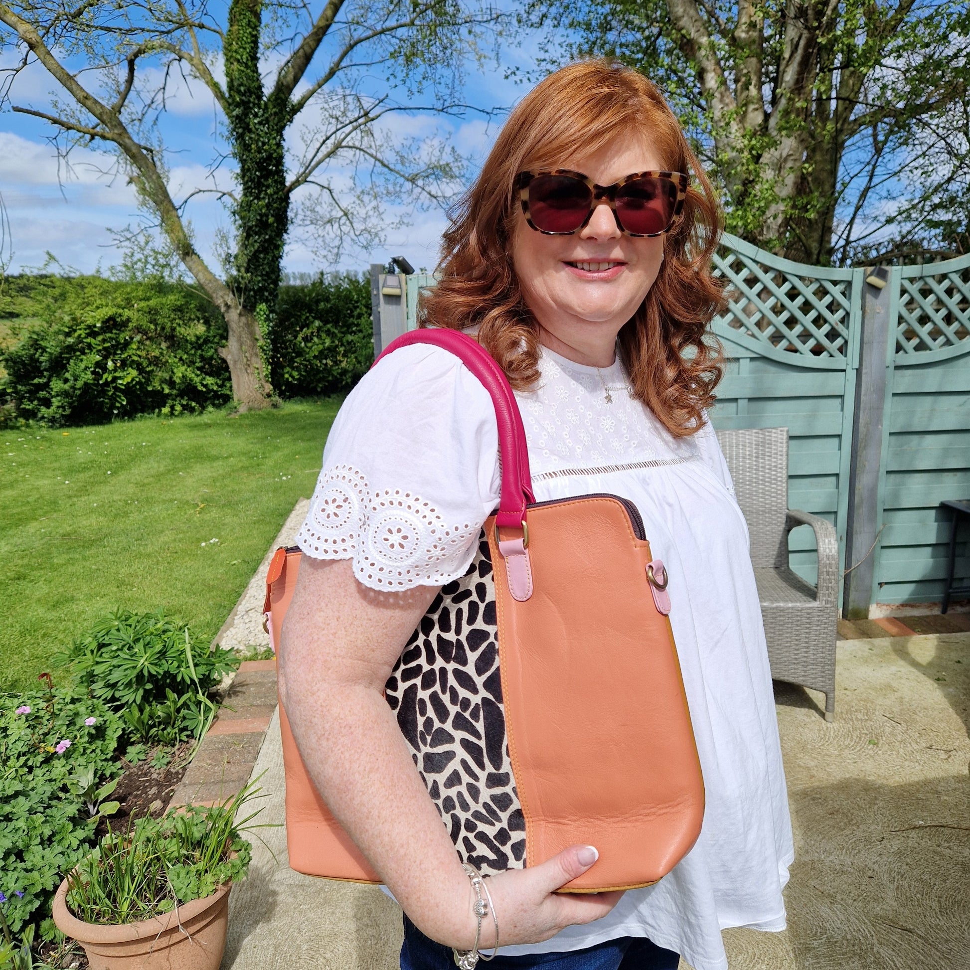 Lady with an all leather tote bag with a giraffe animal print panel.