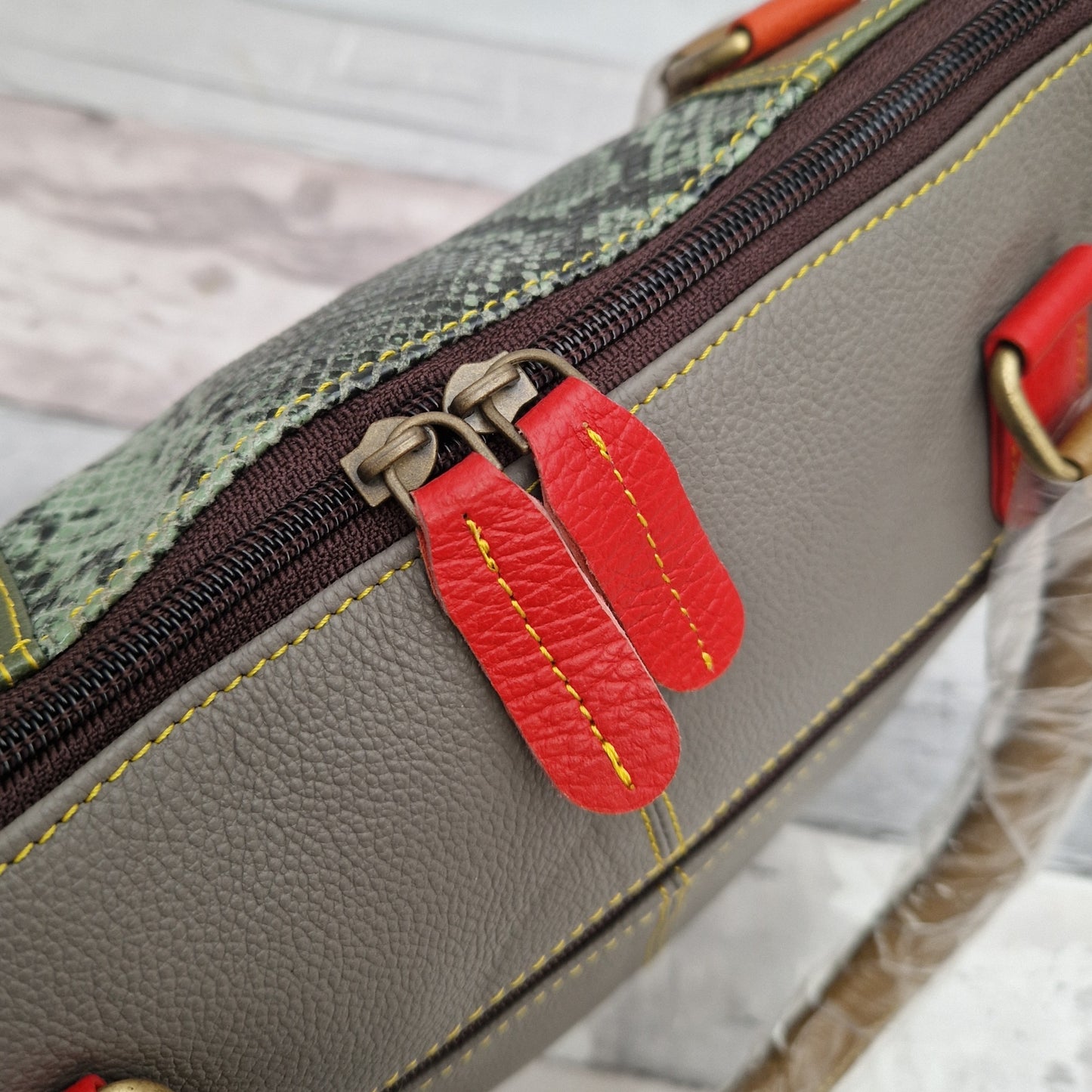 Close up view of an all leather tote bag with double zip closer.