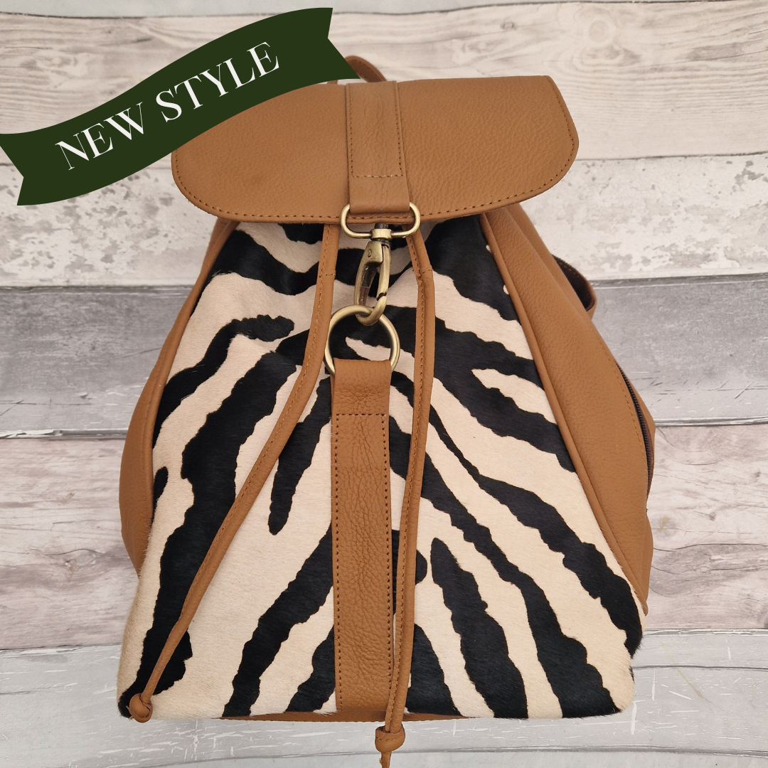 Tan leather back pack with textured panels of black and white zebra print.