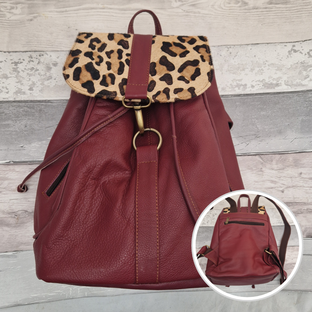 Burgundy leather back pack with textured panels of leopard print.