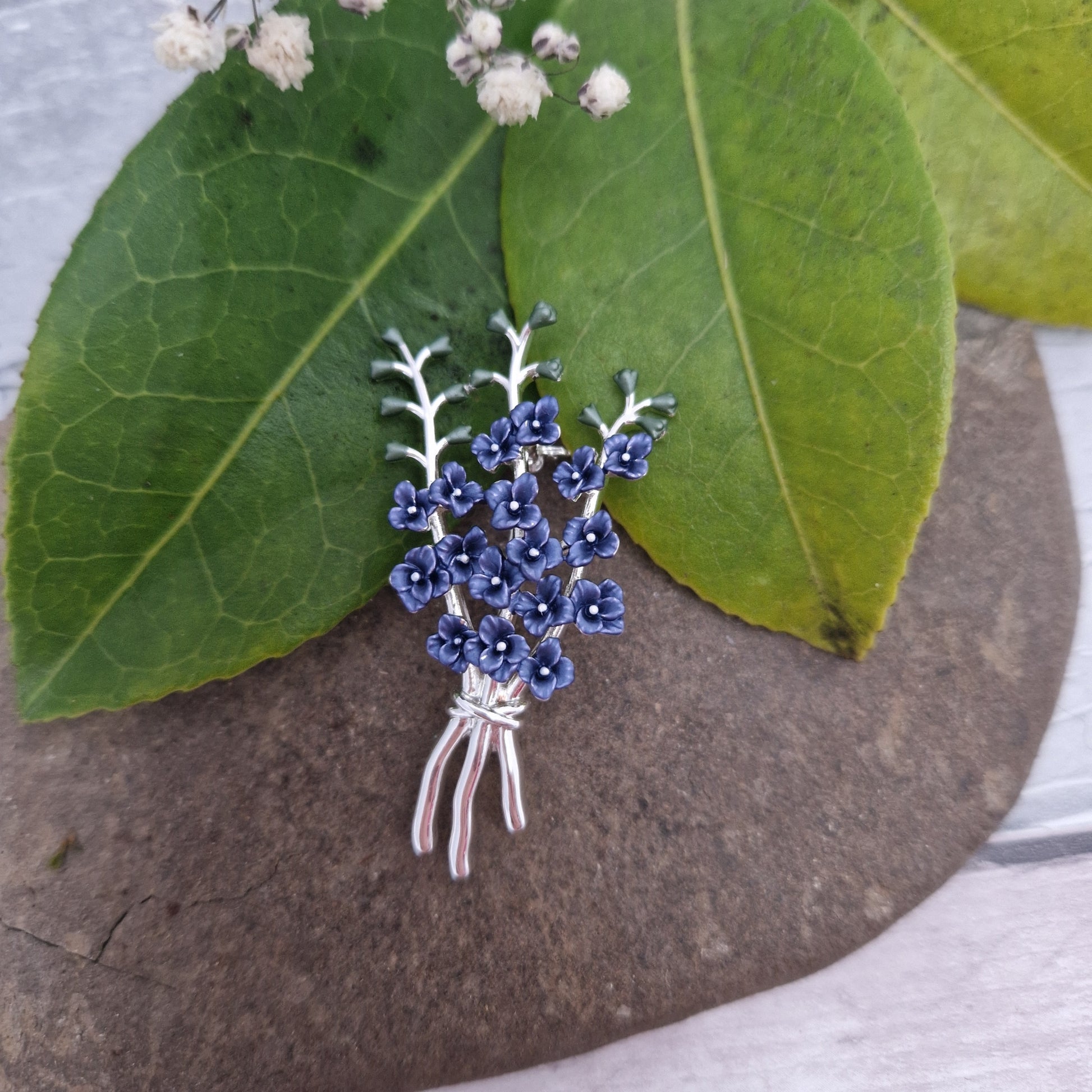 Hand painted inky blue enamel and silver tone brooch featuring 3 tall delphinium flower stems bunched together.