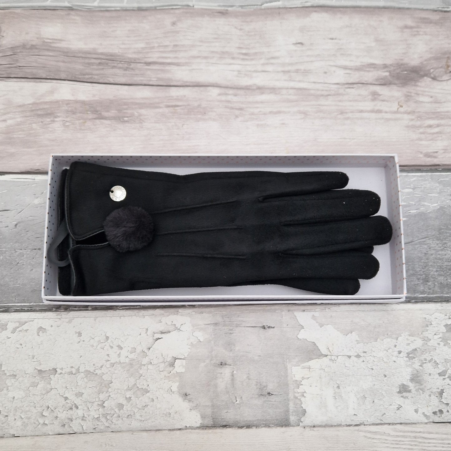 Gift Boxed black suede gloves with a pom pom detail at cuff.