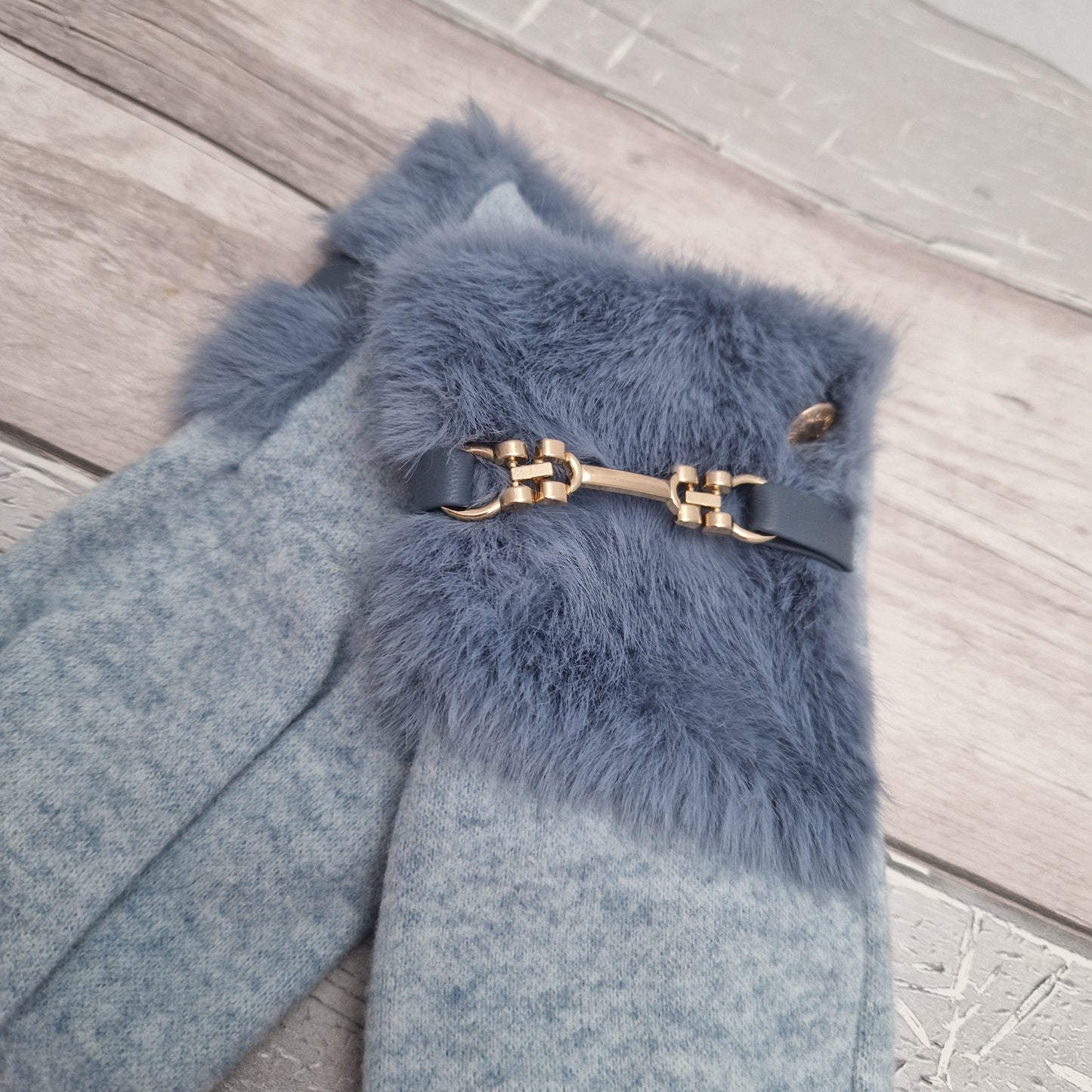 Power blue coloured ladies stretch gloves with a large faux fur cuff finished in a gold coloured bar buckle detail.