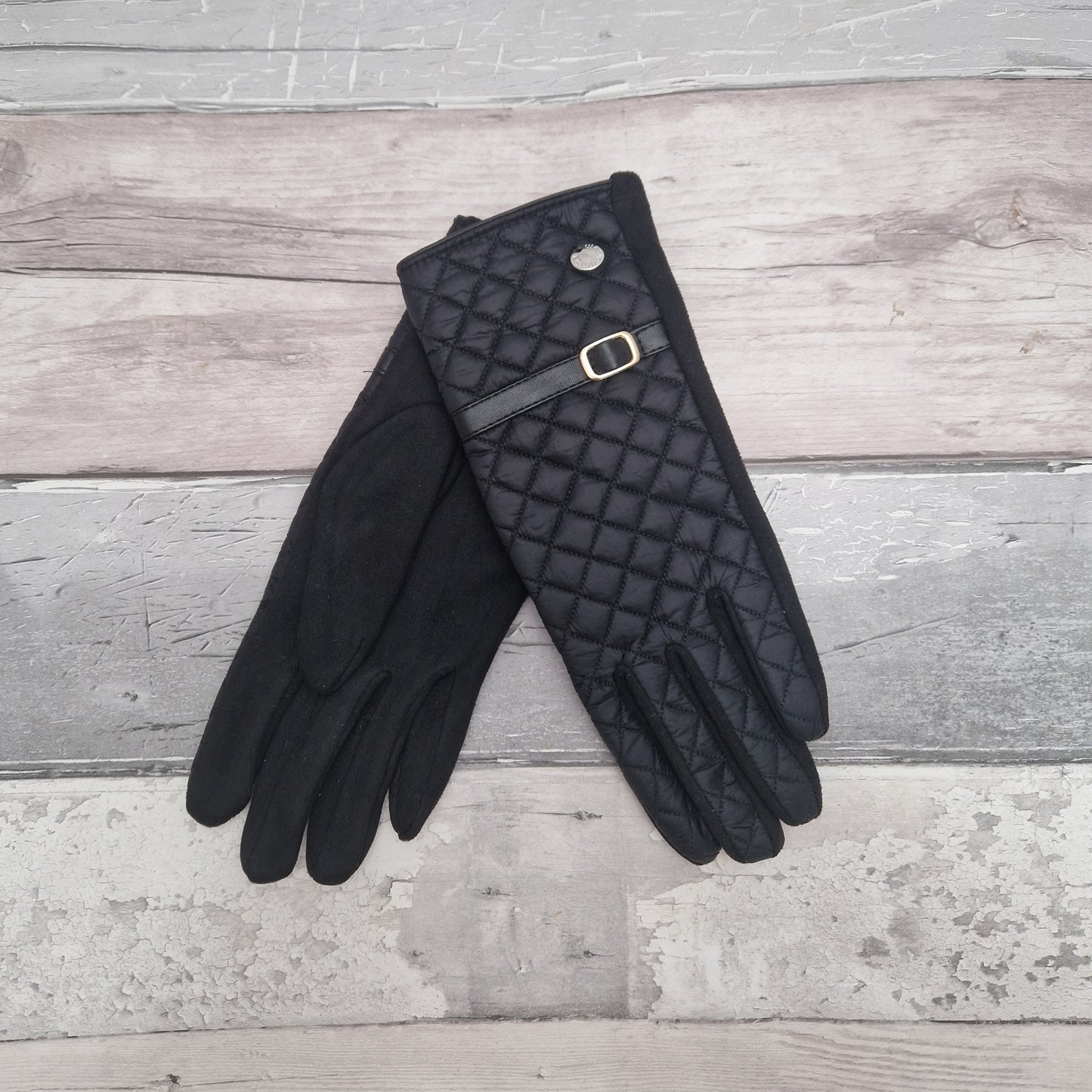 Black ladies gloves quilted with a strap and buckle detail.