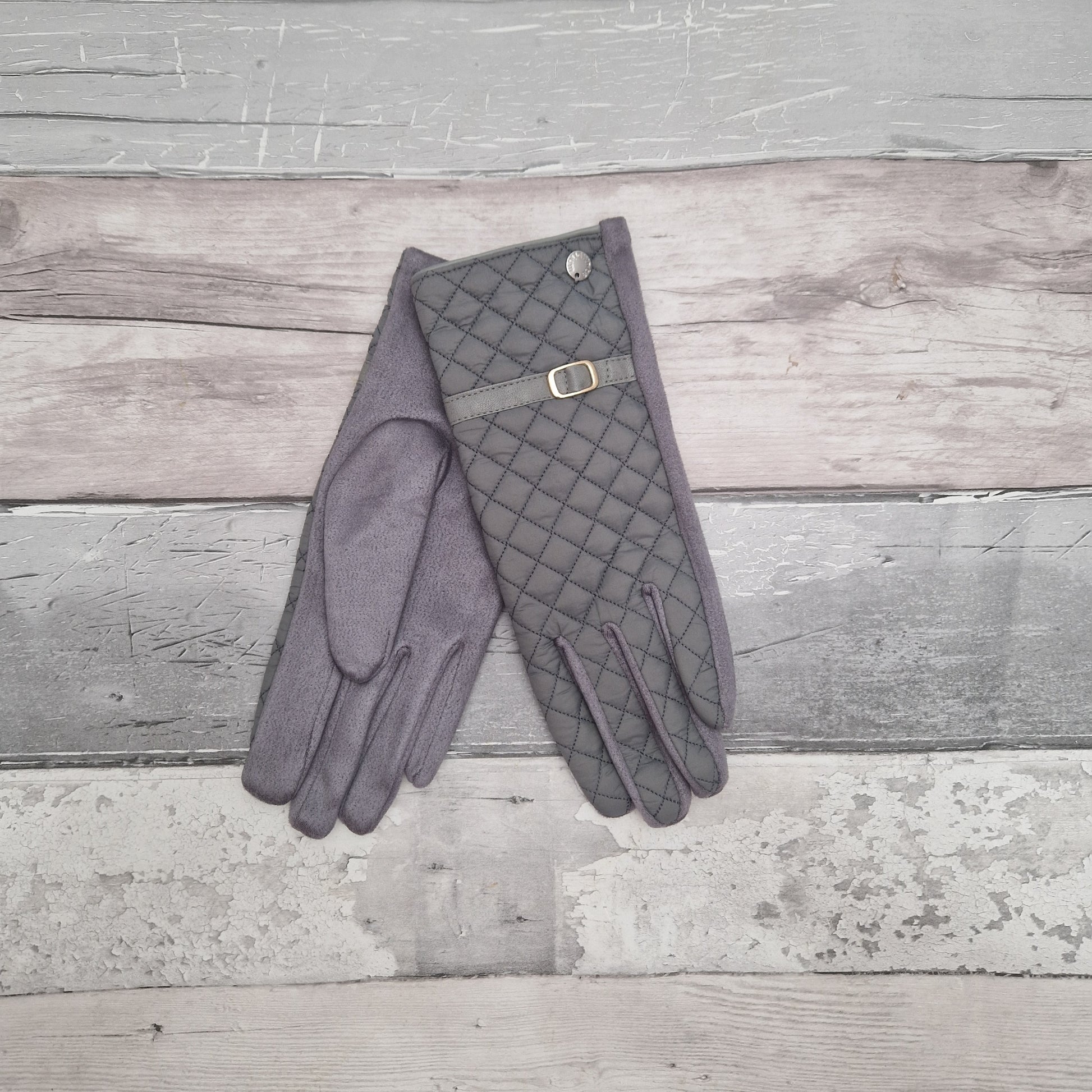 Grey ladies gloves quilted with a strap and buckle detail.