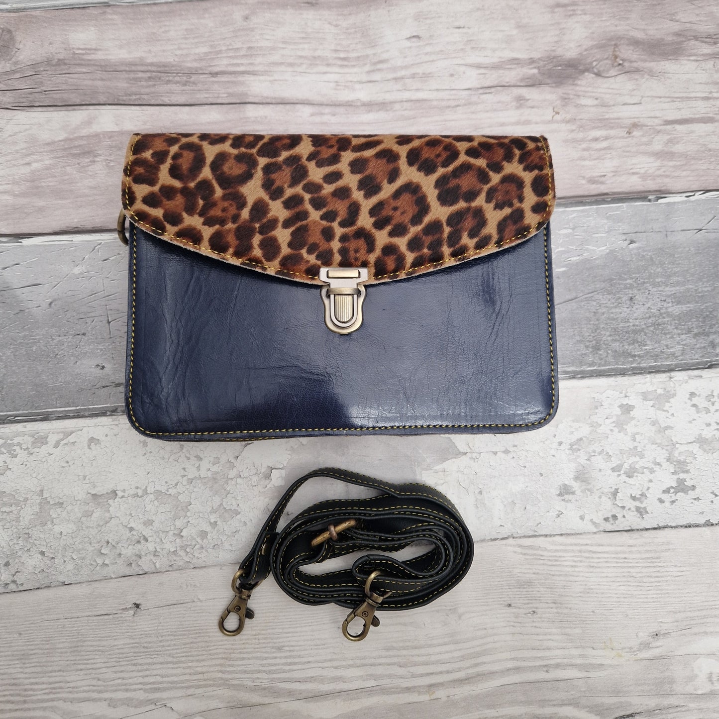 Navy Patent leather envelope style crossbody bag with a textured panel in brown Jaguar print.