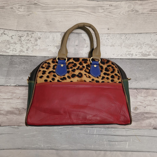 Bowling  bag style handbag made from leather off cuts in a variety of different colours. Textured panel of cow hide has been decorated with a striking Jaguar print.