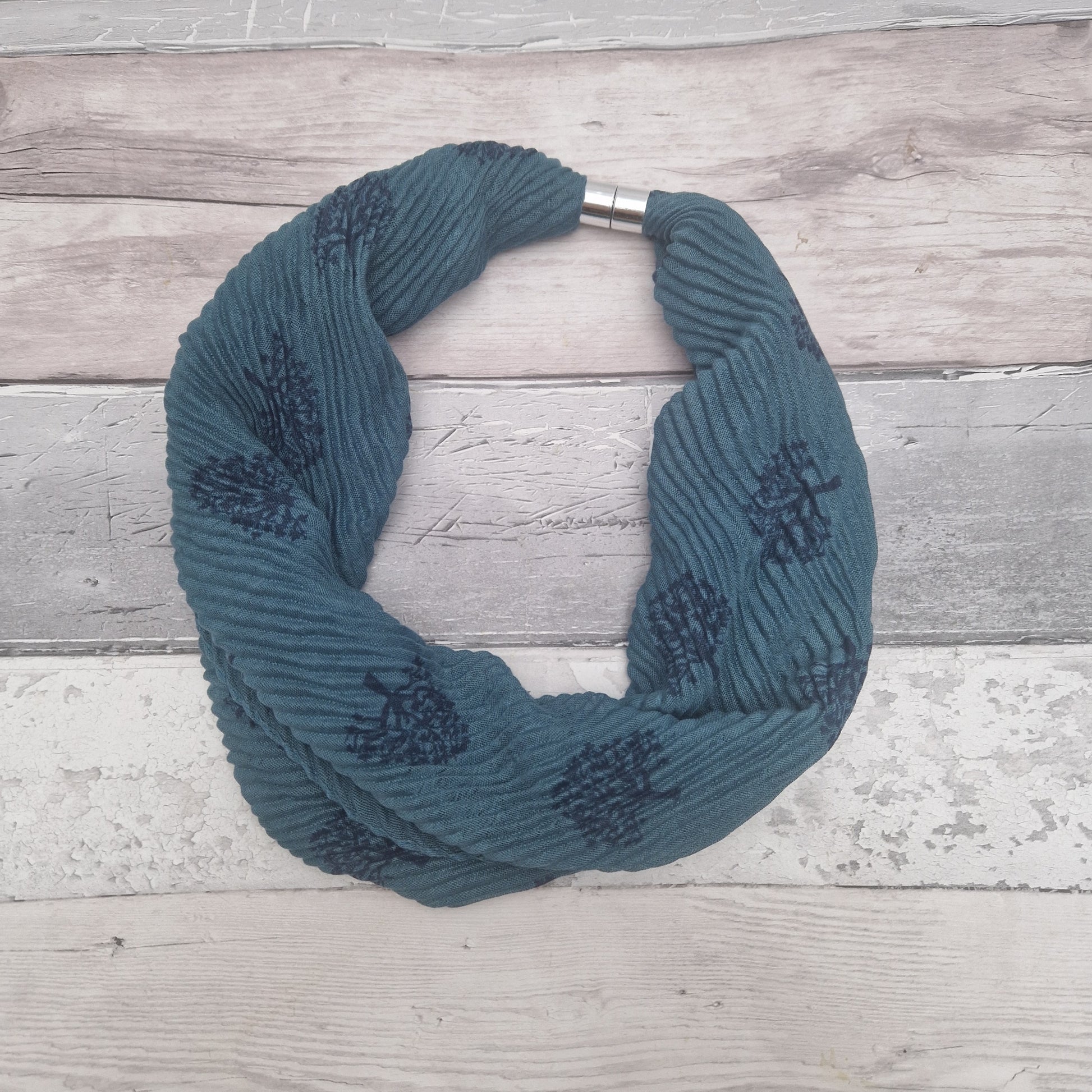 Turquoise coloured neck scarf with a tree of life print and silver magnetic closers.