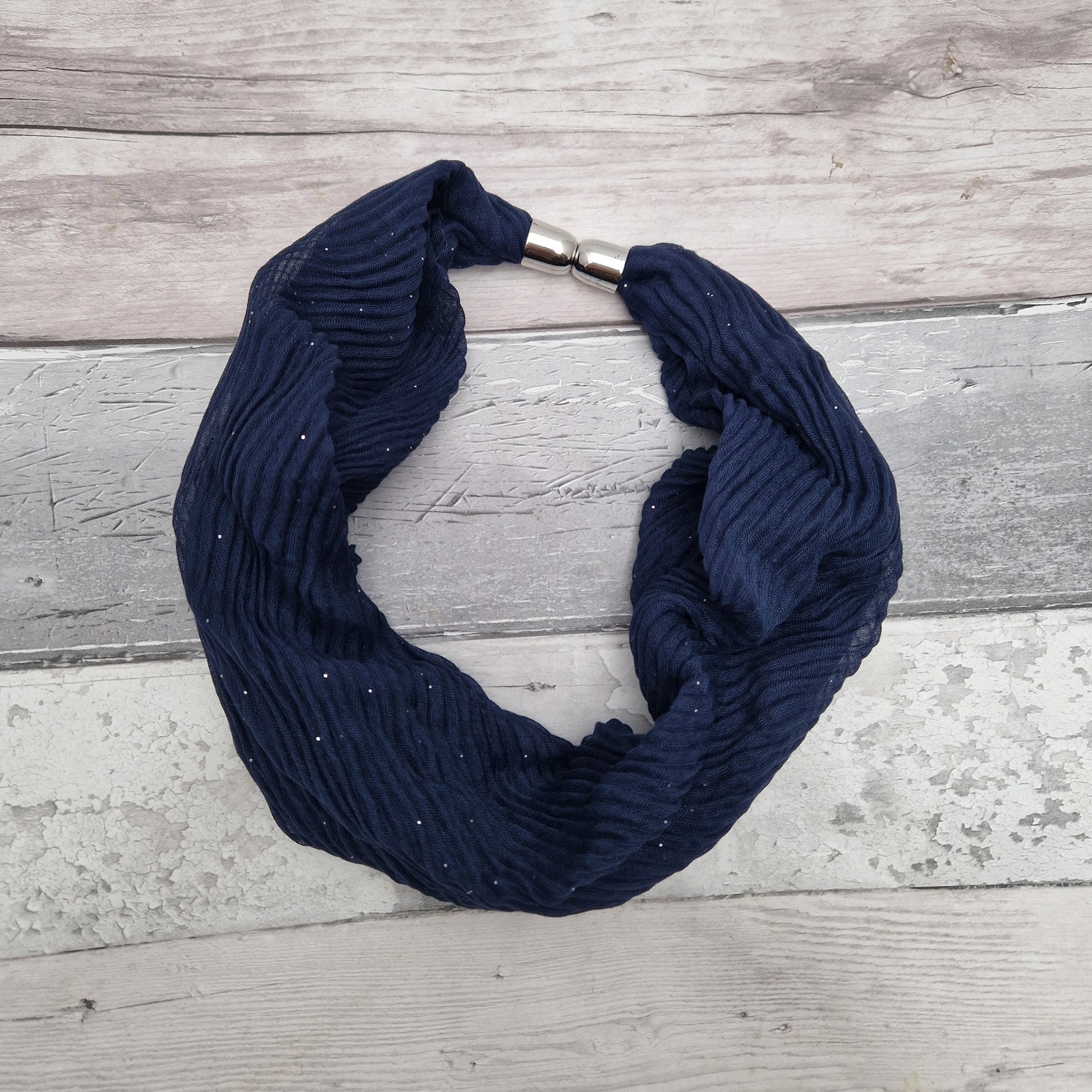 Navy coloured neck scarf with a crinkle texture and a fine silver sparkle and silver magnetic closers.