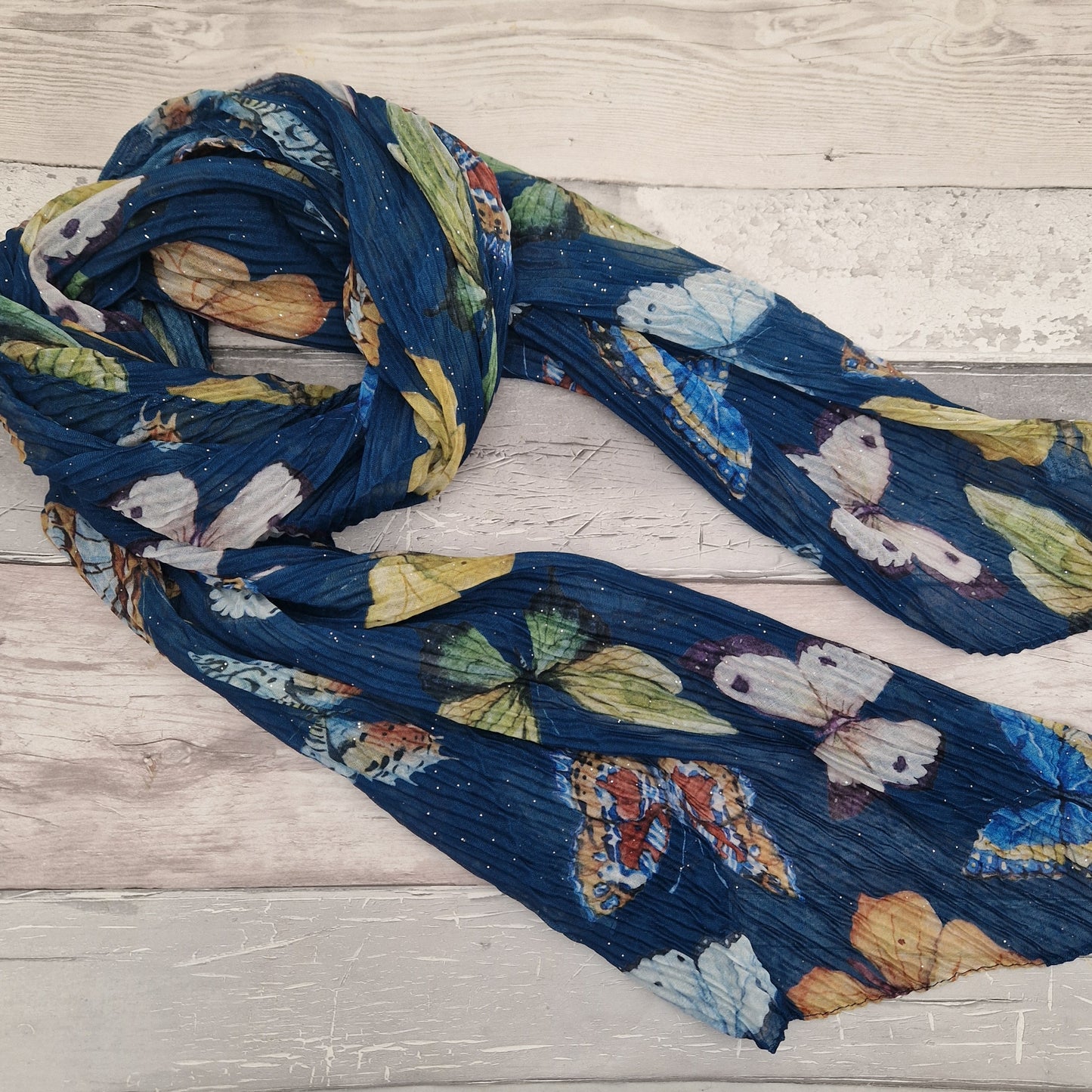 Crinkled textured scarf in blue with very pretty collection of butterfly images in different colours.