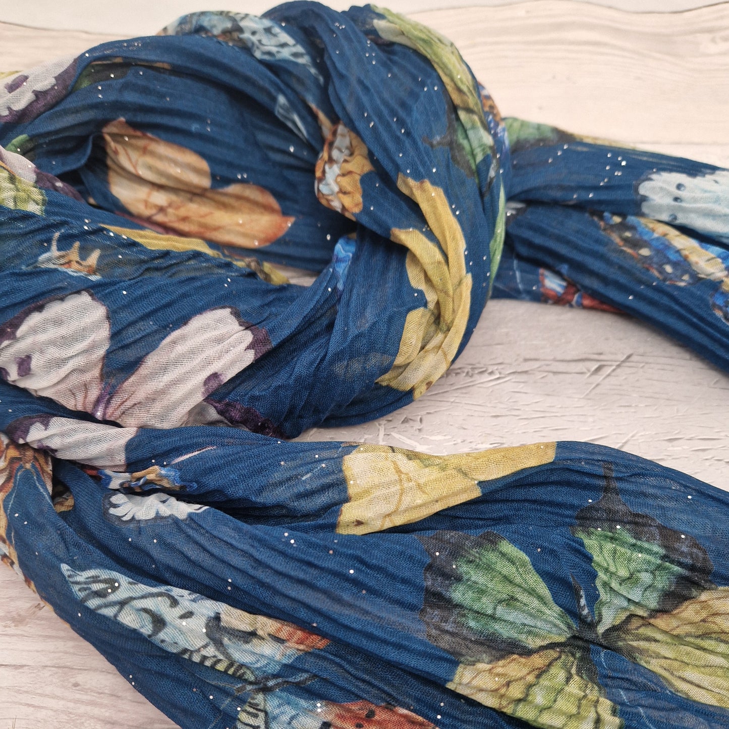 Crinkled textured scarf in blue with very pretty collection of butterfly images in different colours.