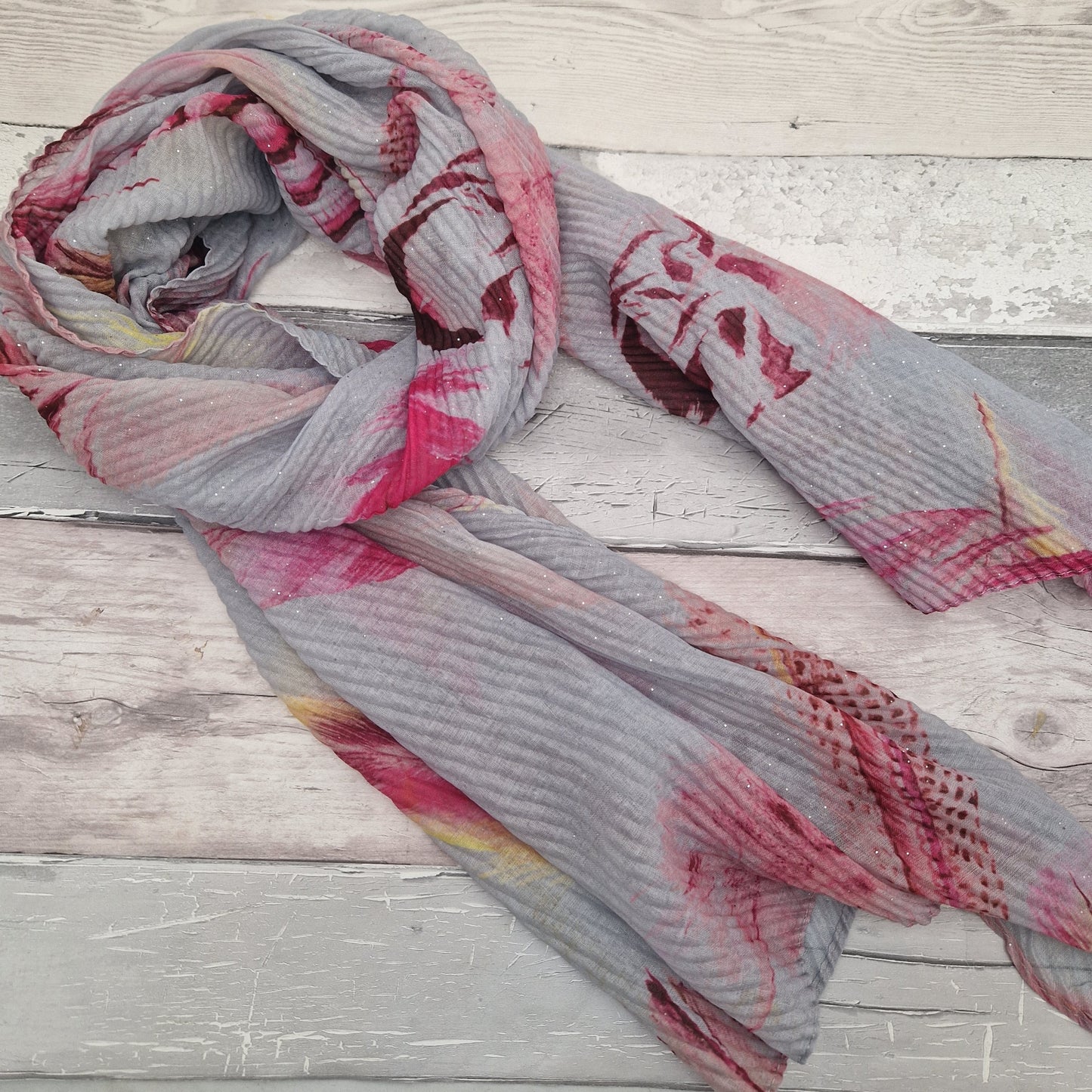 Crinkle effect pale grey scarf decorated with feathers in yellow, baby pink and hot pink.