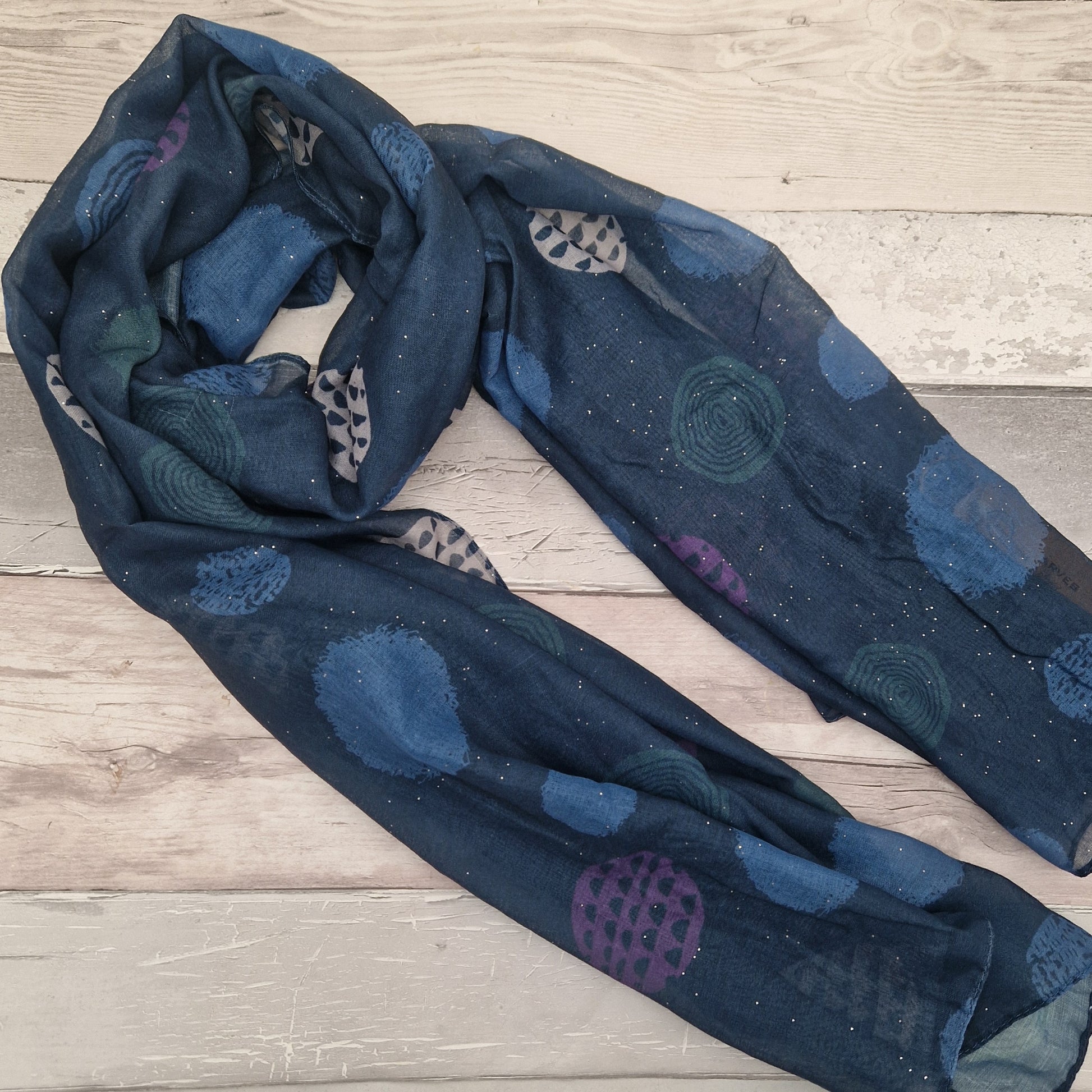 Blue coloured scarf decorated with abstract circles in contrasting colours.