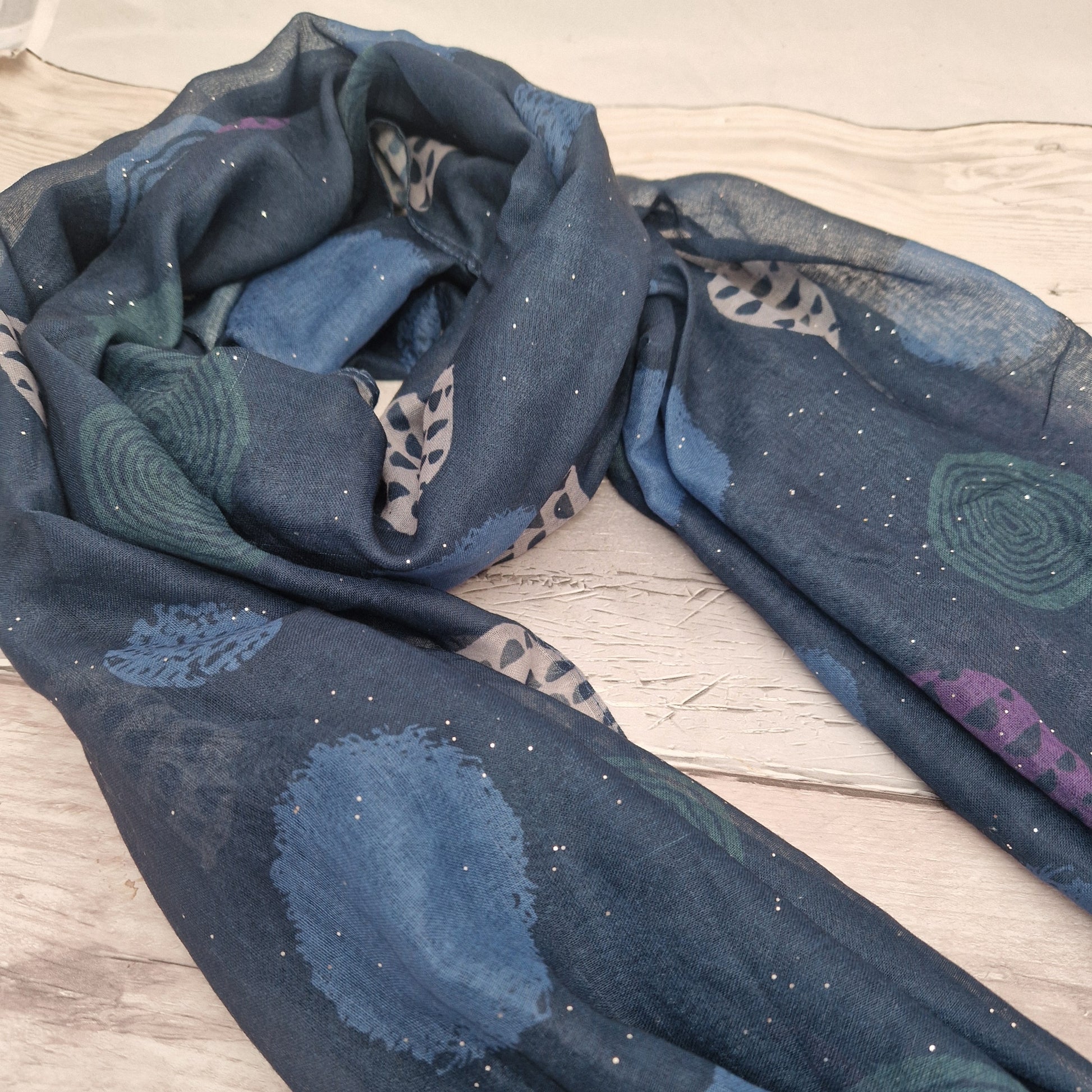 Blue coloured scarf decorated with abstract circles in contrasting colours.