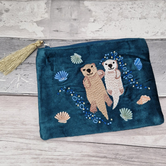 Turquoise velvet pouch with hand embroidered relief featuring  Otters and a mix of pretty sea shells.