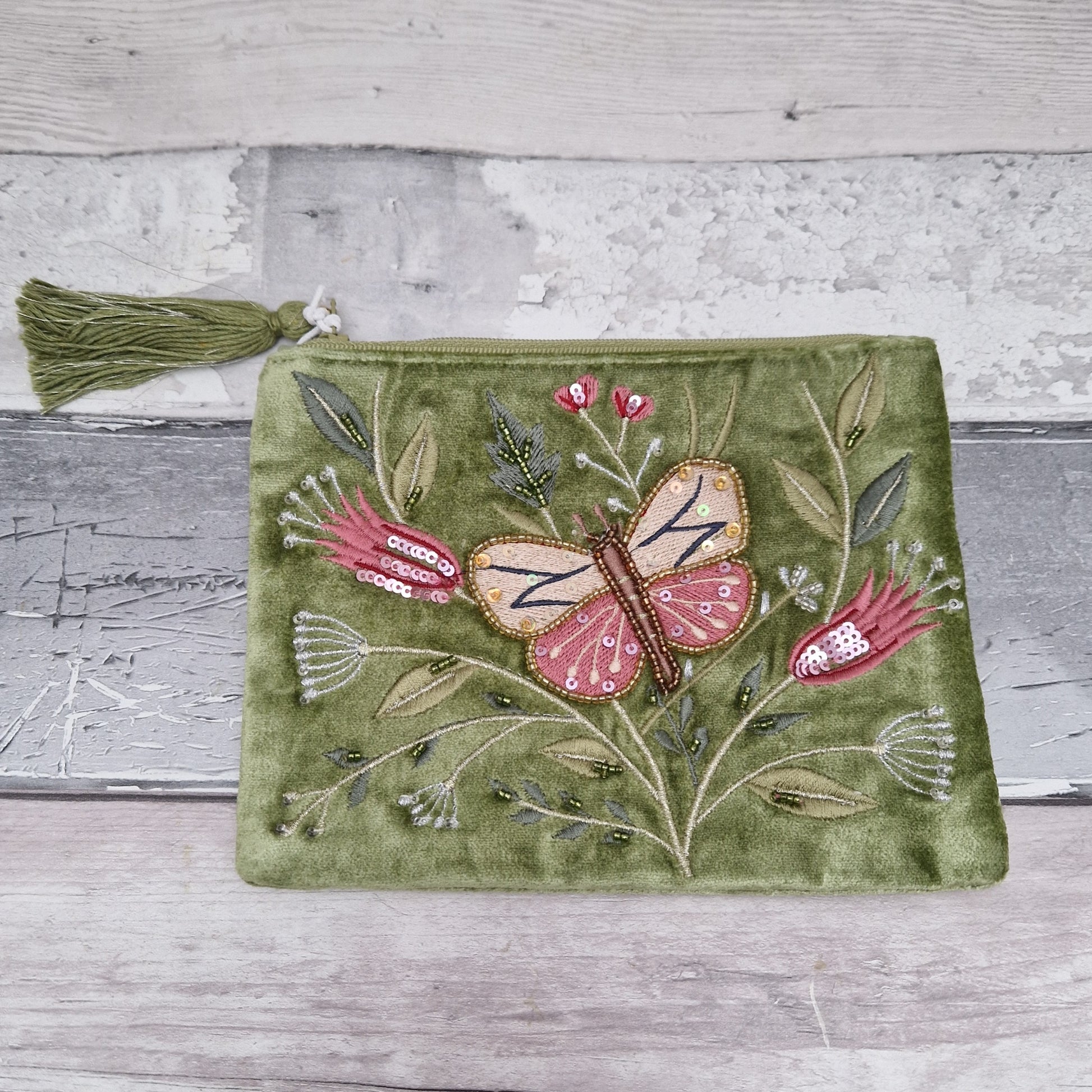 Green velvet pouch with hand embroidered relief featuring a large butterfly amongst matching pink flowers.