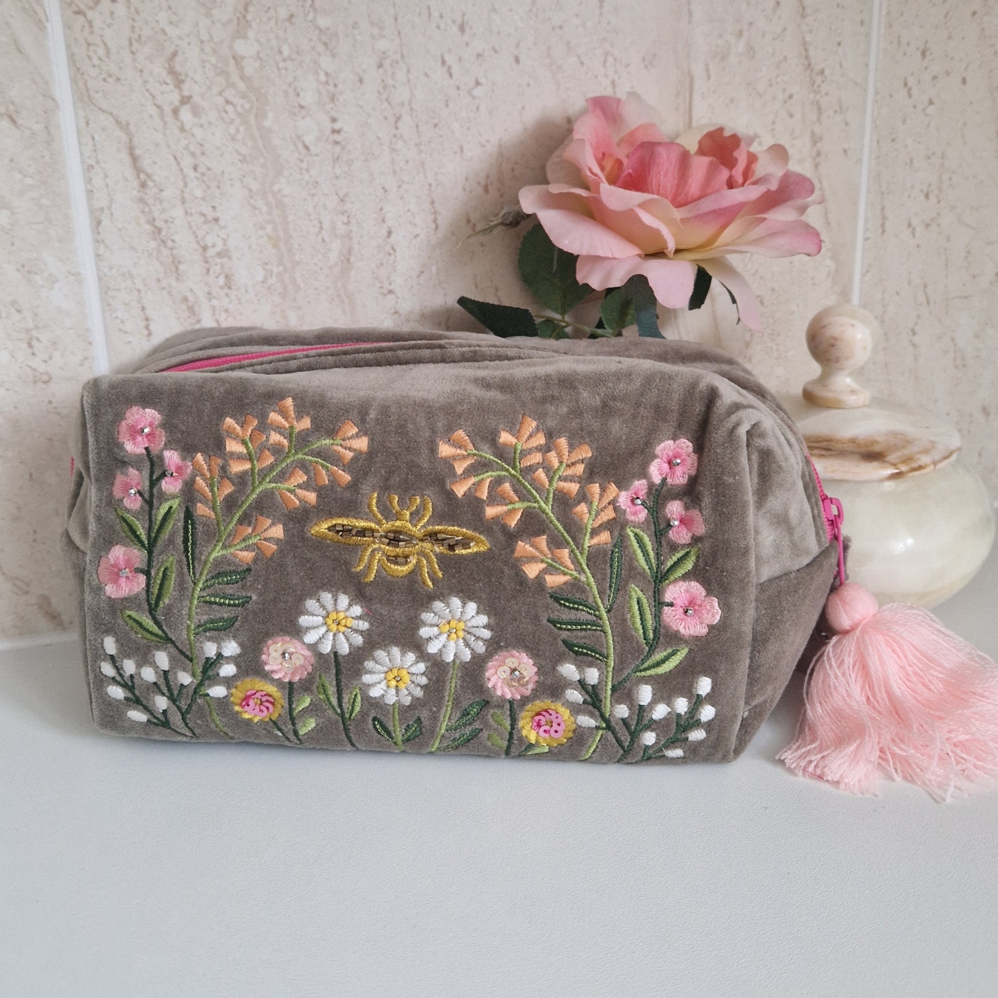 Sage coloured velvet washbag hand embroidered with sequins and beads. Depicting a flower garden with a central golden coloured bee.