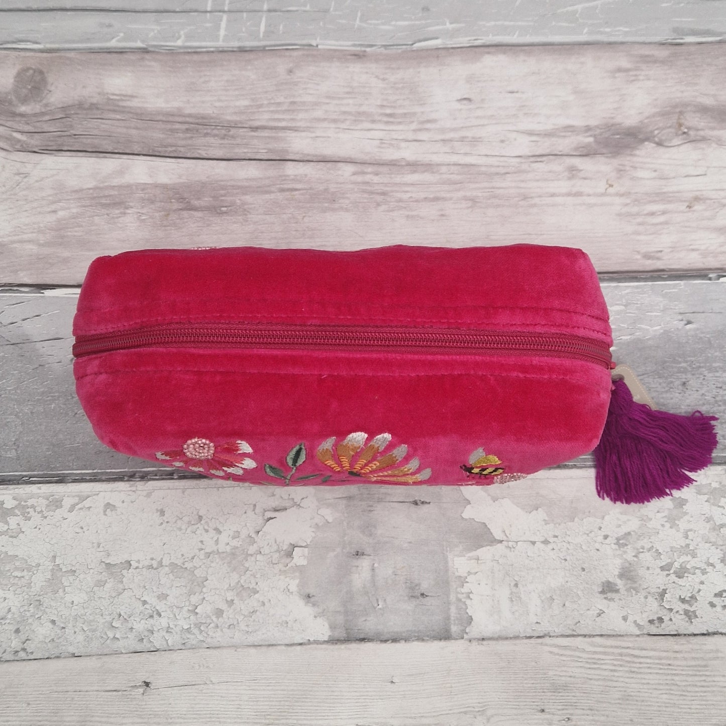 Top down view of a hot pink velvet wash bag.