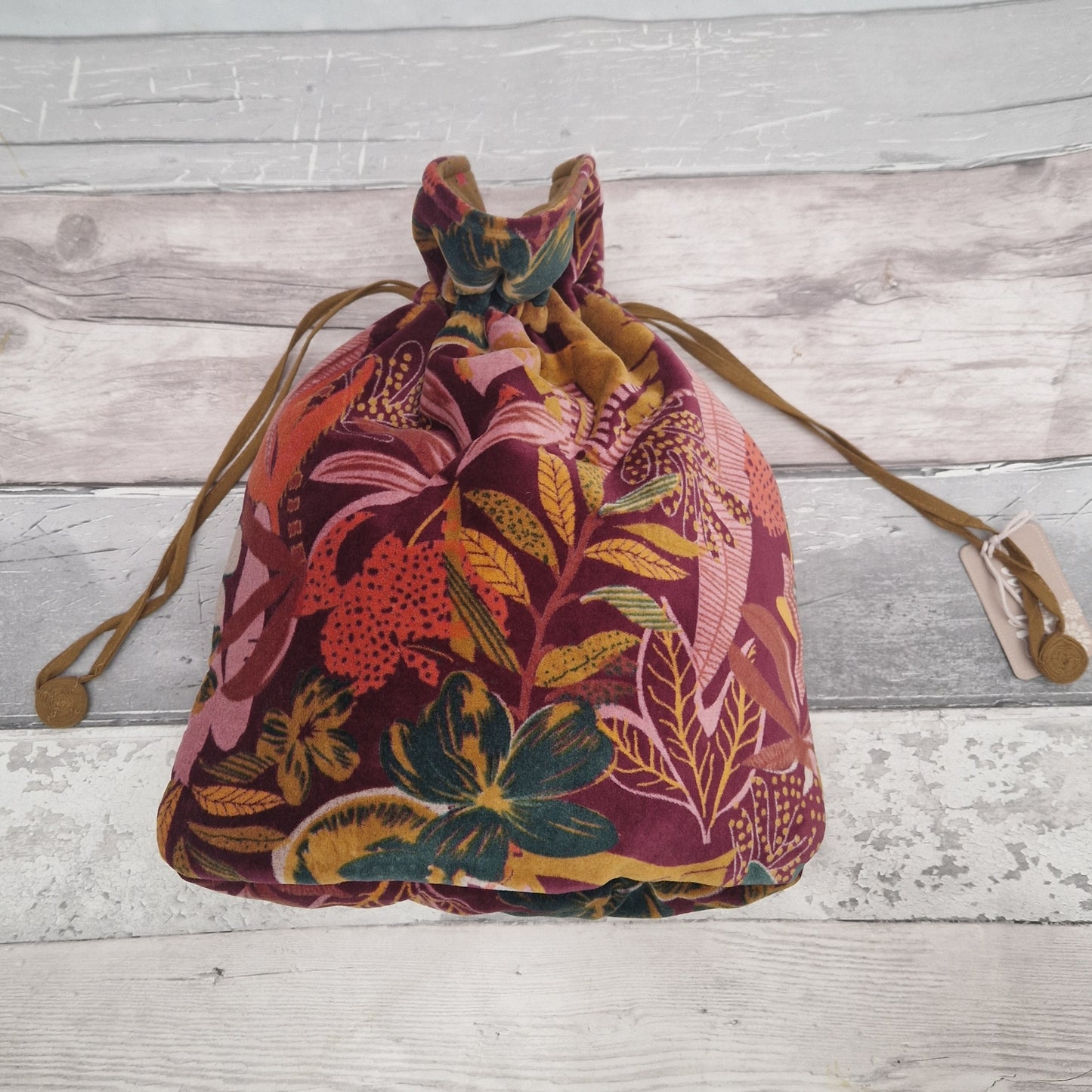 Large drawstring velvet pouch decorated in rich colours depicting a tropical flower garden.