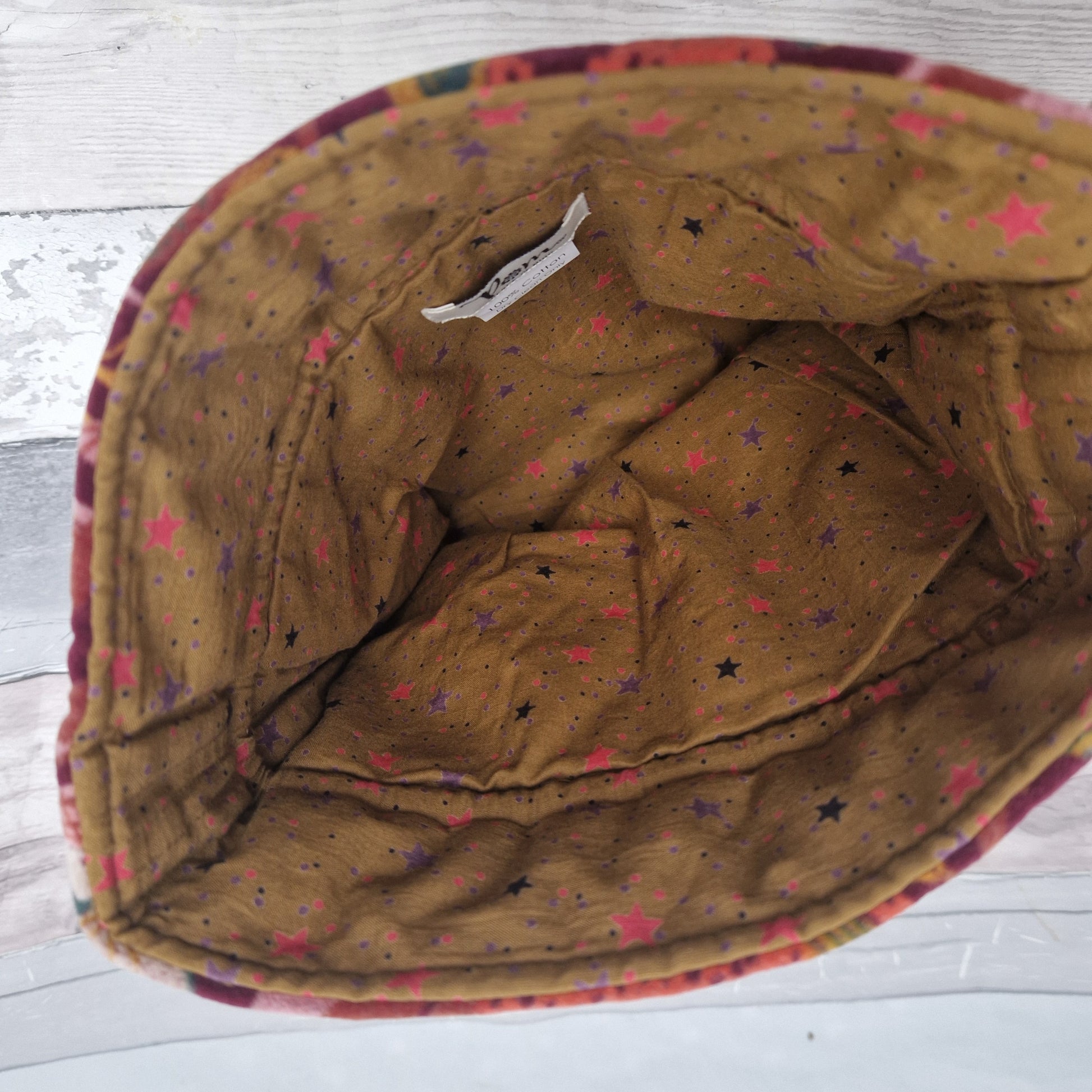 Inside view of our drawstring pouch showing a mustard coloured lining decorated in stars.