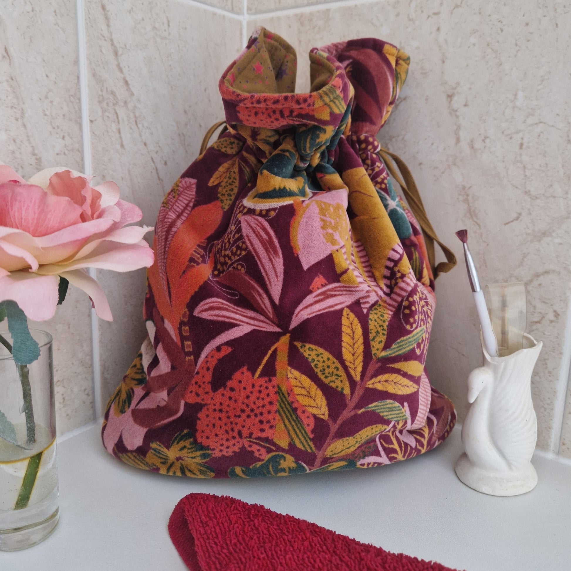 Large drawstring velvet pouch decorated in rich colours depicting a tropical flower garden.