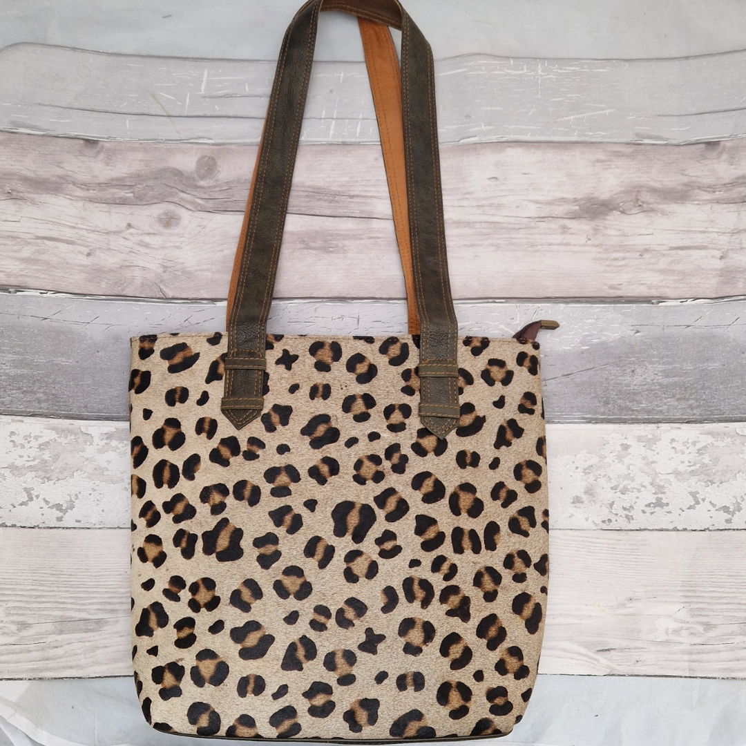 All leather tote bag made with textured panels decorated in Leopard print. Long handles in green leather.