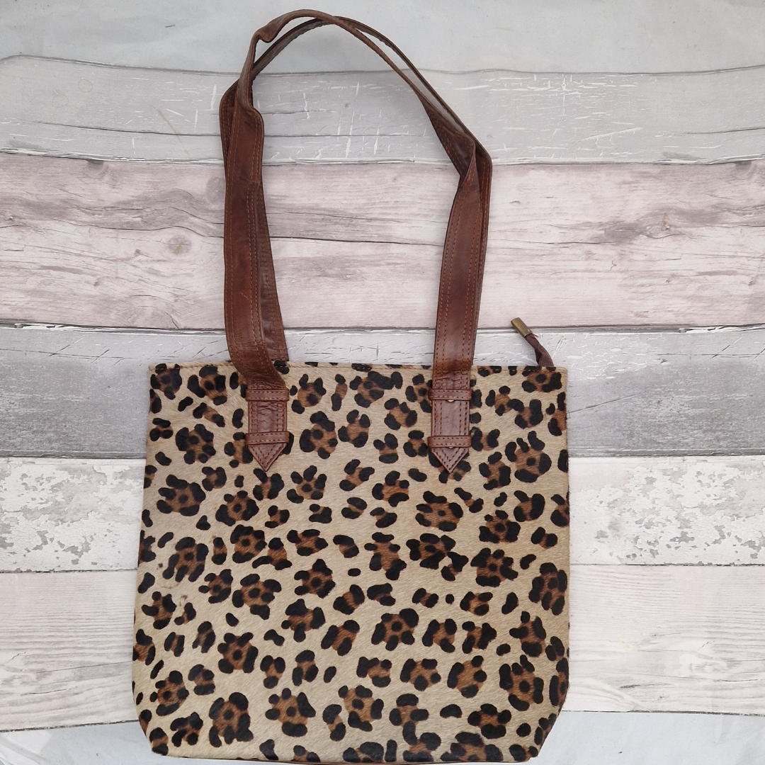 All leather tote bag made with textured panels decorated in Leopard print. Long handles in brown leather.