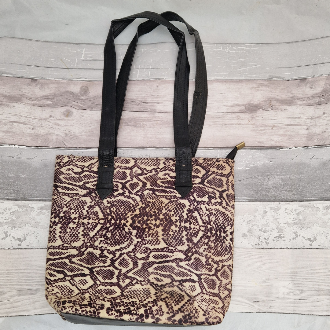 All leather tote bag made with textured panels decorated in Snake print. Long handles in black leather.