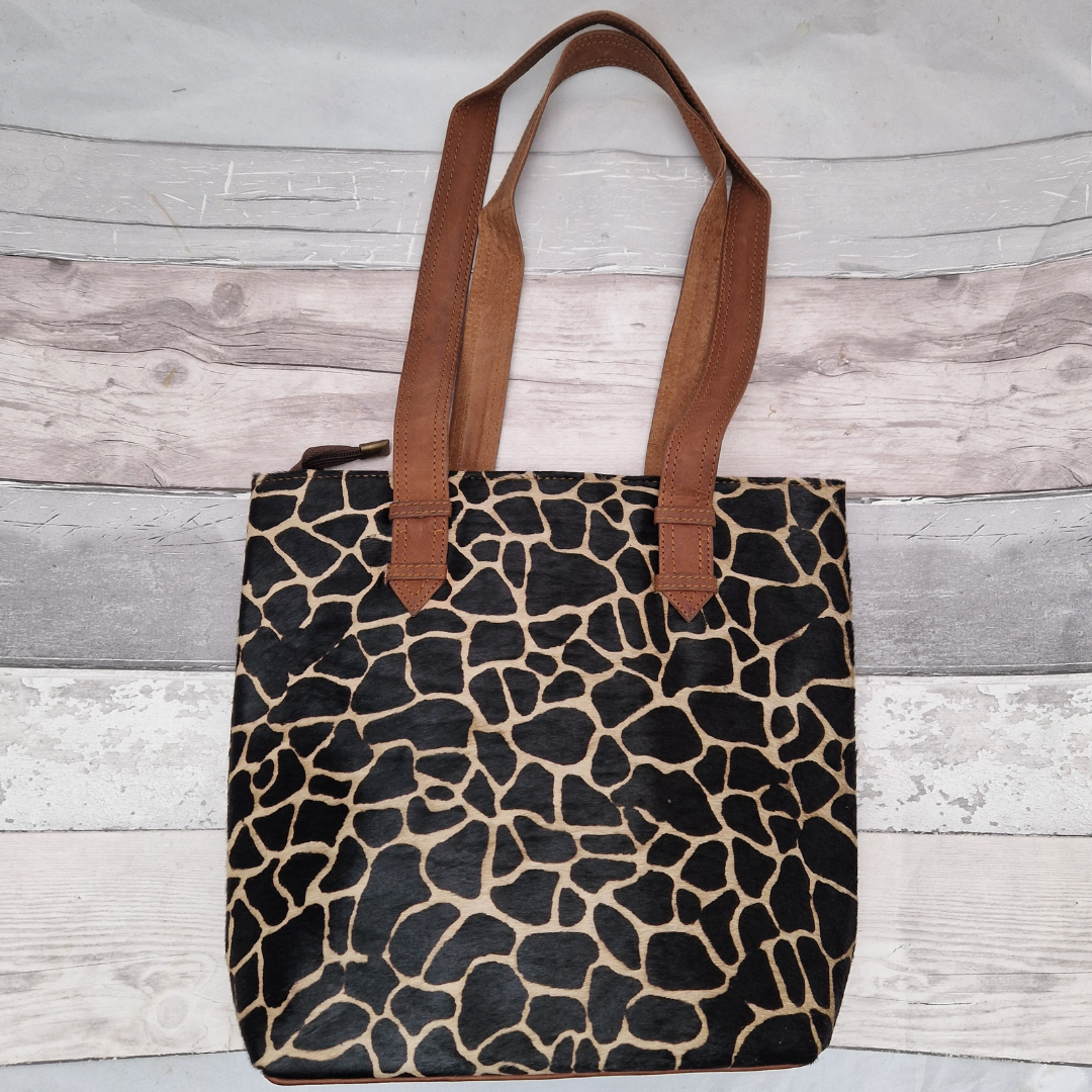 All leather tote bag made with textured panels decorated in Giraffe print. Long handles in brown leather.