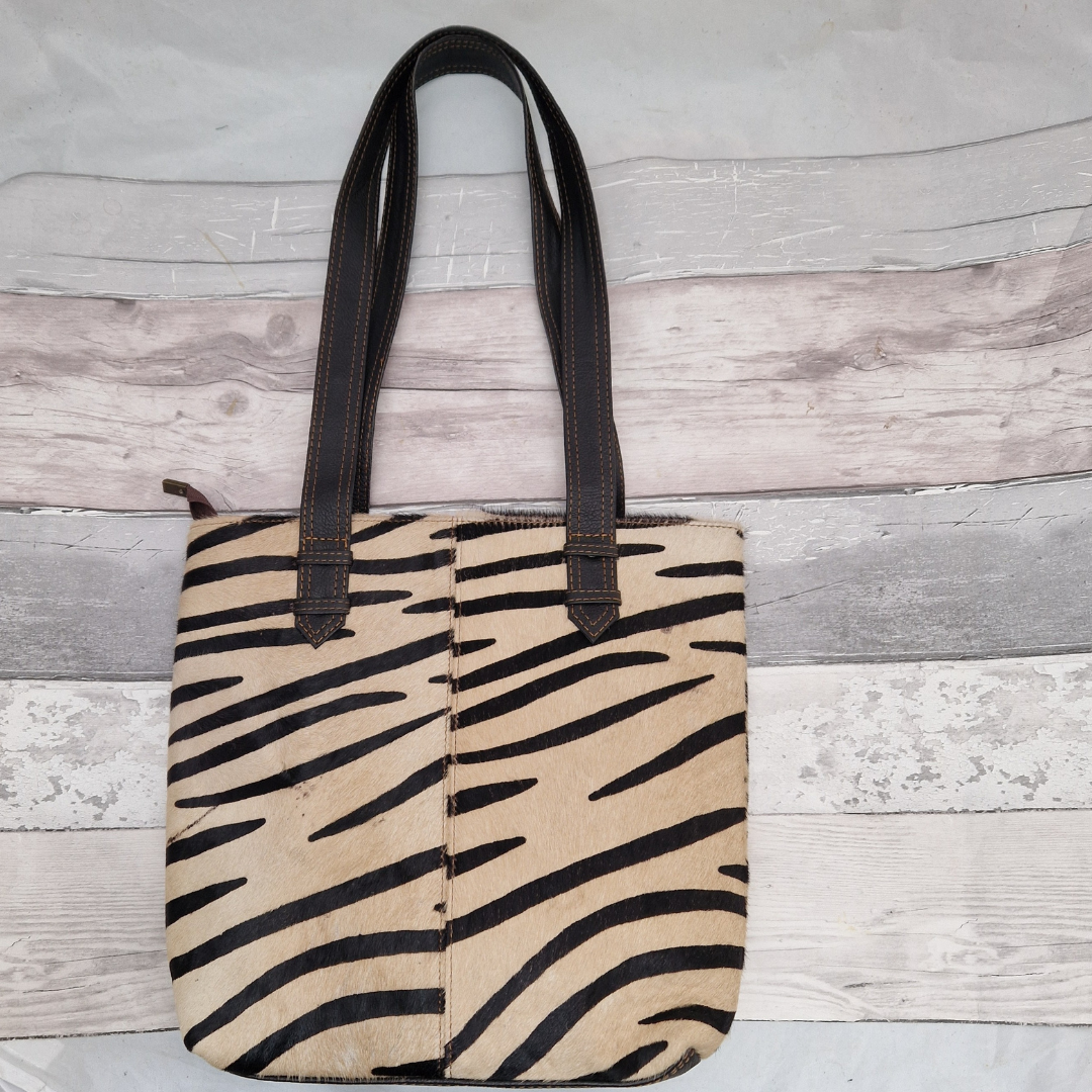 All leather tote bag made with textured panels decorated in Zebra print. Long handles in black leather.