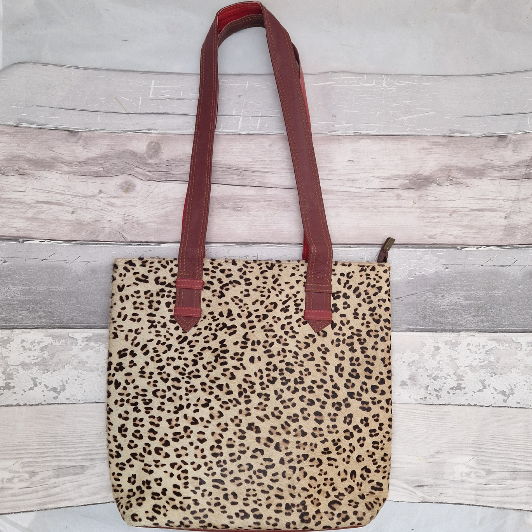 All leather tote bag made with textured panels decorated in Leopard print. Long handles in red leather.