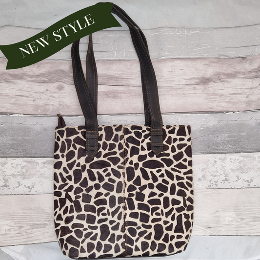 All leather tote bag made with textured panels decorated in Giraffe print. Long handles in black leather.