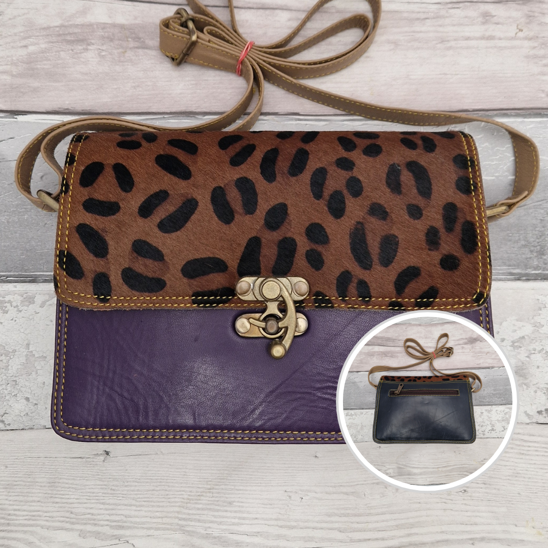 All leather purple coloured bag with a textured panel of animal print. A brass swivel clasp secured the bag at the front.